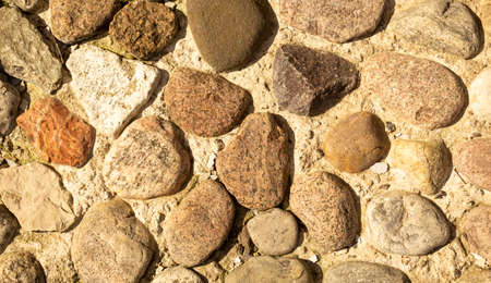 Different gray stones lie on the ground, stone background.