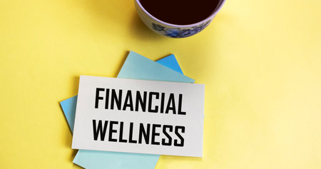 Financial wellbeing text written on a notepad with a mug of coffee next to itの写真素材