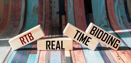 Real-time trading text, RTB, on wooden blocks, beautiful background