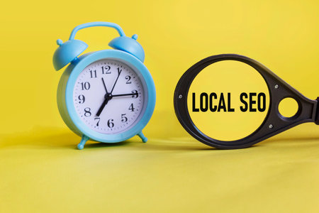 Local SEO writing on a magnifying glass, on a yellow background with a clock