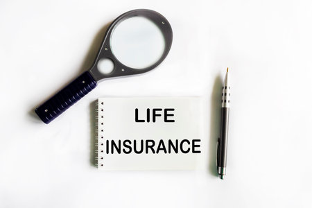 Life insurance word on notepad with magnifying glass and penの写真素材