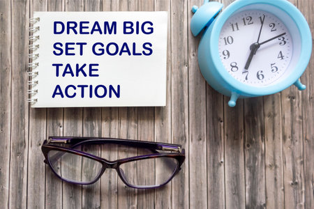 Dream Big Set Goals Take Action text quote on notepad, concept background