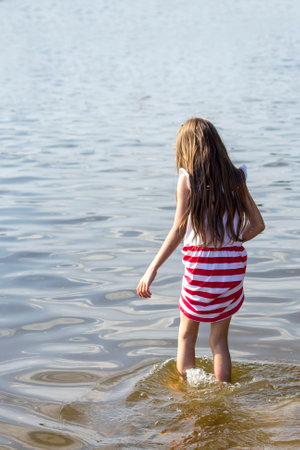 The girl enters the lake in a beautiful dressの写真素材