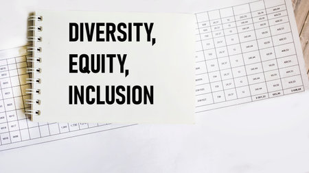 The word Diversity, Equity and Inclusion on a notepad with papers and numbers on a wooden background. DEI concept for business. Copy spaceの写真素材