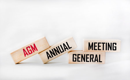 AGM is the symbol of the annual general meeting. Concept word AGM on wooden cubes. White...