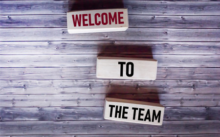 WELCOME TO THE TEAM text concept on wooden blocks on wooden backgroundの写真素材