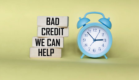 Wooden blocks with the inscription Question about bad credit history, we can help on a yellow background with a clock.の写真素材