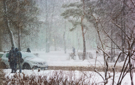 Image of heavy snowfall. People walking in bad weather along a city street. Snow storm in the city.