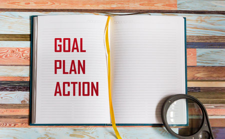 Goal, plan, action concepts with text in notepad and magnifying glass. Business management,...