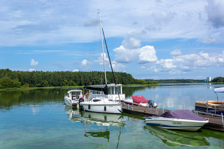 small boats and yachts stand at the pier of the European seaport on a bright sunny summer day at sea.の写真素材