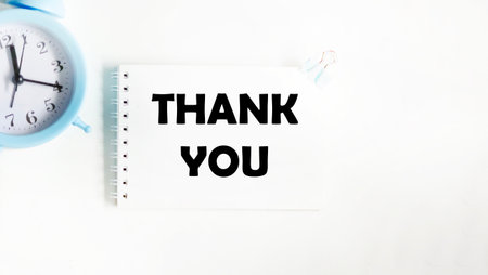 A thank-you card with a clock on a white background, written in a thank-you letterの写真素材