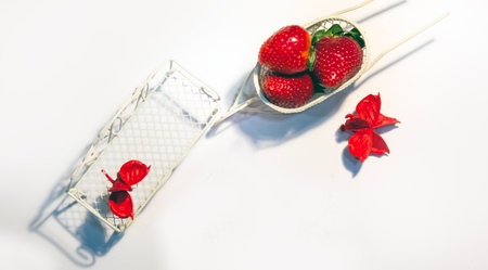 A toy cart and a bench for decorating strawberries in rustic style on a white backgroundの写真素材