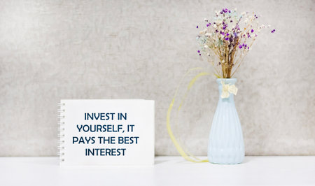 The inscription Invest in yourself, it pays the best interest, appears on a white notebook.の写真素材