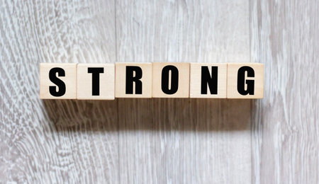 The word "strong" written in wooden letters on a gray backgroundの写真素材