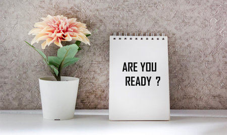 The text You are ready is written on a notebook with a flower on a light backgroundの写真素材