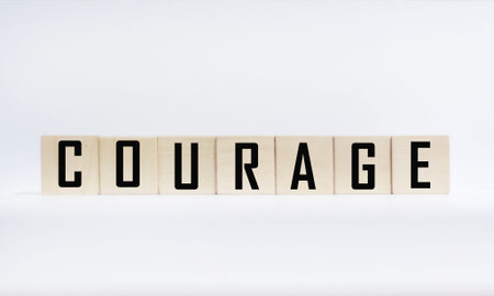 Courage is a word written on wooden blocks on a white background