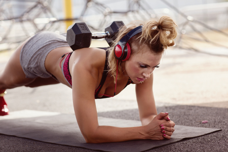 Beautiful athletic girl doing fitness outdoors. Front viewの写真素材
