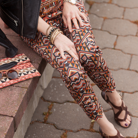 Street, bright style. A young woman in the costume with ornament,black jacket, clutch, sandals, sunglasses. Details. Sguare image photoの写真素材