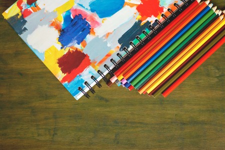 Color pencil and sketchbook on wood tableの写真素材