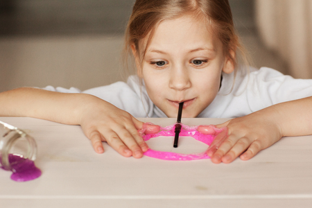 The child is holding a toy called mucus, the child is having fun and experimenting.の写真素材