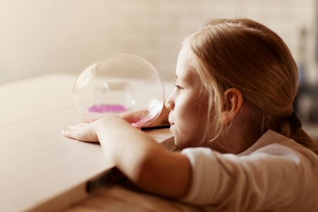 The child is holding a toy called mucus, the child is having fun and experimenting.