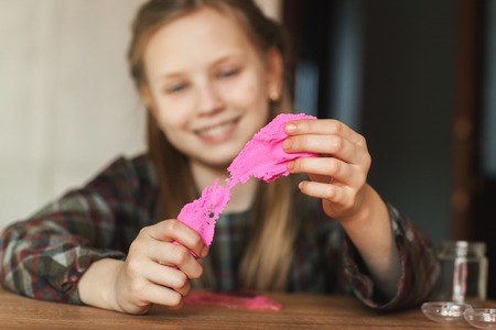 The child is holding a toy called mucus, the child is having fun and experimenting.の写真素材