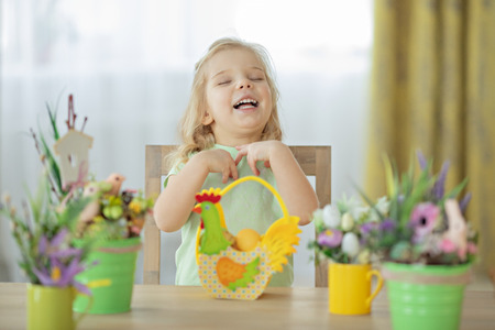 Cute little girl making decoration for Easter. Easter bouquet, eggs, easter, traditions.
