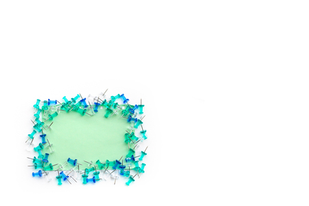 Blue, turquoise and transparent buttons laid out on note paper, on an isolated white background, with space for text, top view.の写真素材
