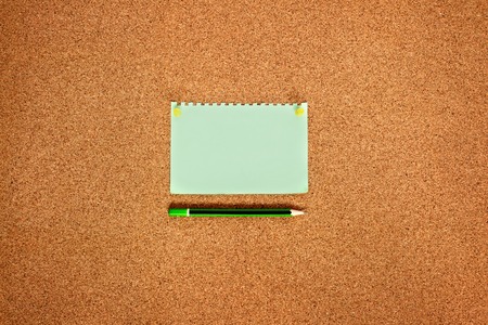 Note paper with yellow buttons and a cork board pencil, top viewの写真素材