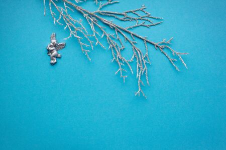 Silver branch with an angel on a blue background. With place for text. New year, holiday, decorationの写真素材