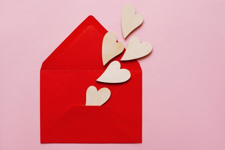 Wooden beautiful hearts in a red paper envelope love message for Valentine's Day and Women's Dayの写真素材