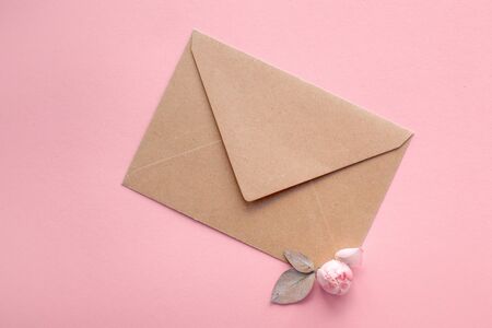 Pink roses on an envelope from kraft paper on a pale pink background. Message for Valentine's Day,...