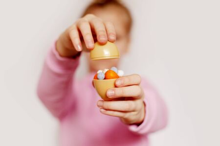 The girl is holding small chocolate eggs lying in one large egg. Concept of the Easter holiday
