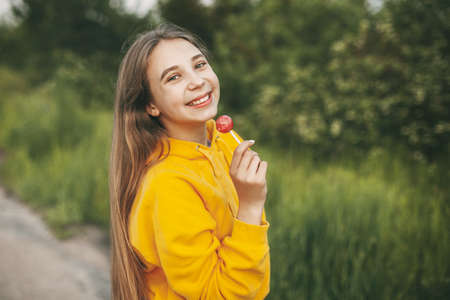 Cute girl with a beautiful smile catches soap bubbles on the background of a beautiful sunset.の写真素材