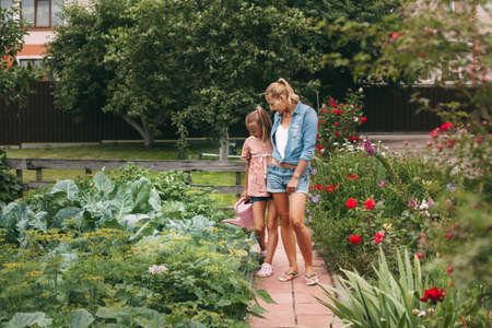 Mother and daughter practice online outdoors near their home during quarantine self-isolation during a pandemic. The family goes in for sports online from home together. Healthy lifestyleの写真素材