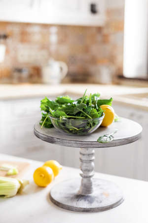 Fresh organic vegetables and lemons are on the table in the kitchen. Ingredients for making a green...