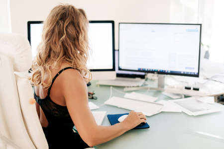 The girl works at the computer in the office. Business, business woman, workplace. Space for text,...