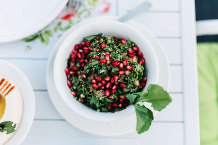 On the table in an Arab restaurant there is a parsley tabbouleh salad with pomegranate seeds. View...
