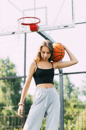 Portrait of young female basketball player. Beautiful teen girl playing basketball. in sportswear...