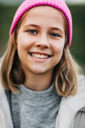 Portrait of smiling stylish teenage girl wearing pink fashion capの写真素材