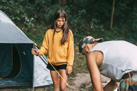 A happy father and daughter are setting up a camping tent. Family time, family rest, careの写真素材