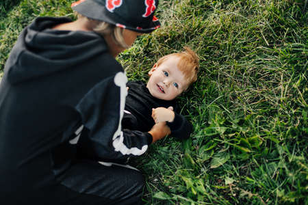 A girl in a hat and a skeleton costume plays with her younger brother on the grass in the garden. Halloween, carnival costumes, holidayの写真素材
