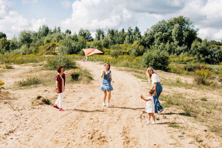 A little girl with her family is flying a kite. Family weekend, family timeの写真素材