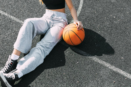 Close-up of a girl with a basketball on a sports field or a school stadiumの写真素材