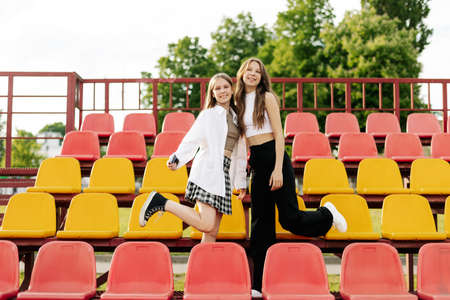 Teenage girls relax together in the school stands. The concept of friendship and relationshipsの写真素材