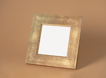 Golden photo frame on brown background, top view. Mockup for design