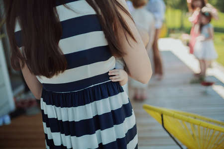 Back view of a girl in a striped dress standing in the park