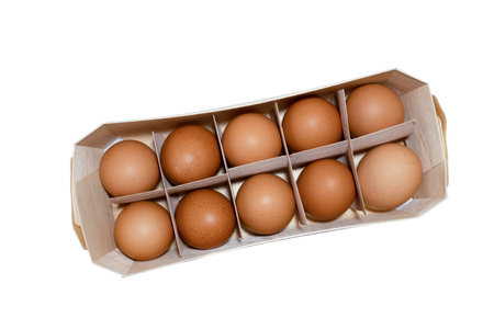 Brown raw chicken eggs in egg wooden box isolated on white background.の写真素材
