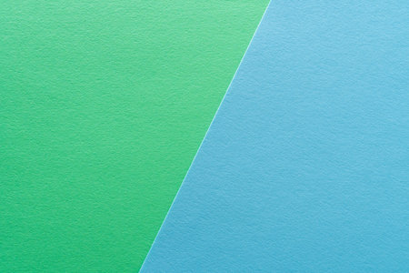 Paper texture background of pastel green and blue colors. Sheets of blank light green and light blue paper with fine texture devided by a sloping border.の写真素材