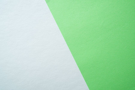 Beautiful paper background of two parts white and light green. Sheets of blank white and light green paper with fine texture separated by a sloping border.の写真素材